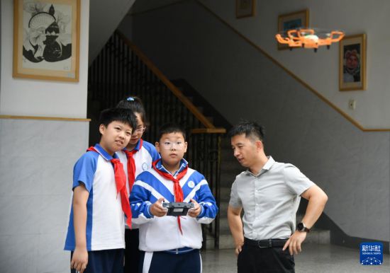 5月26日，在西安市新城區華山實驗小學，學生在老師的指導下操作無人機。新華社記者 張博文 攝