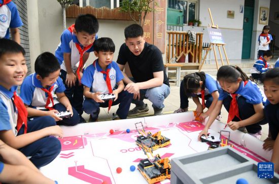 5月26日，在西安市新城區華山實驗小學，學生在老師的指導下進行機器人游戲。新華社記者 張博文 攝