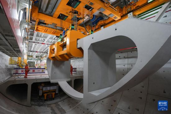 5月29日，中鐵十四局技術人員在甬舟鐵路金塘海底隧道“甬舟號”盾構機內操作箱涵吊機拼裝弧形構件。新華社記者 黃宗治 攝