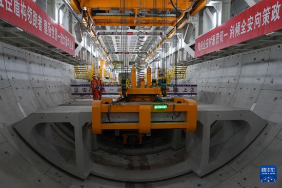 5月29日，中鐵十四局技術人員在甬舟鐵路金塘海底隧道“甬舟號”盾構機內操作箱涵吊機拼裝弧形構件。新華社記者 黃宗治 攝
