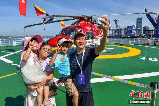 图为民众在“雪龙2”号极地科学考察破冰船飞行平台自拍合影
	。中新社记者 骆云飞 摄