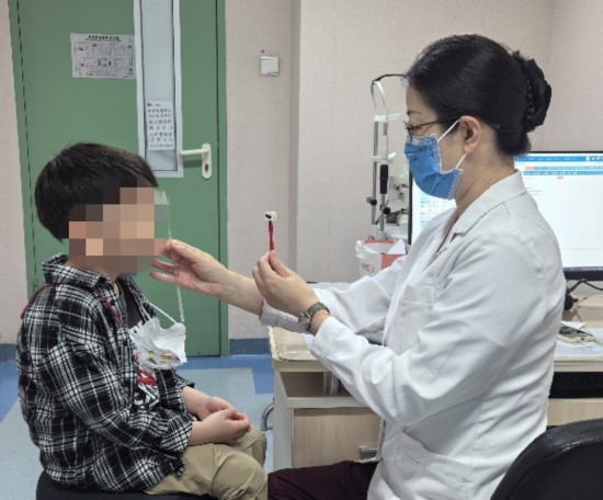 北京大學第一醫院眼科副主任劉海華正在為患兒進行斜視檢查。（北京大學第一醫院供圖）