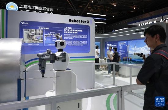 6月11日，參觀者在一個進行作業演示的人形清潔機器人旁駐足觀看。新華社記者 方喆 攝