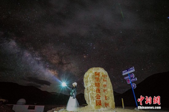 圖為6月20日晚，游客“打卡”西藏阿裡暗夜公園，天上是銀河與流星（右上角）。曹枝清 攝