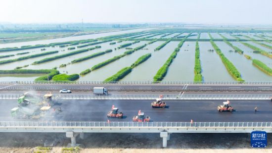 6月23日，中鐵四局一公司施工車輛進行瀝青攤鋪作業（無人機照片）。
