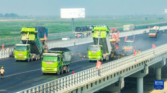 6月23日，中鐵四局一公司施工車輛進行瀝青攤鋪作業（無人機照片）。新華社記者 楊青 攝