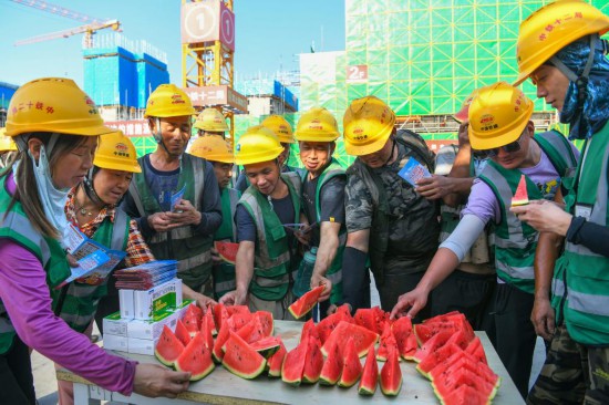 6月11日，在河北雄安新區啟動區西北片區小學項目建設現場，中鐵十二局工人吃西瓜解暑。新華社記者 牟宇 攝
