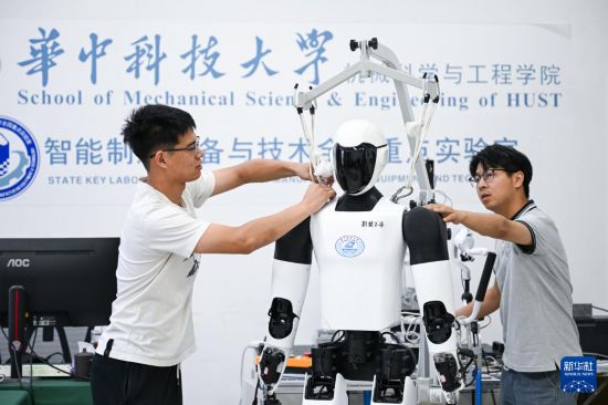 5月29日，在华中科技大学机械科学与工程学院，博士研究生丁涛（右）与博士研究生林宇辰放置“荆楚”人形机器人。新华社记者 杜子璇 摄