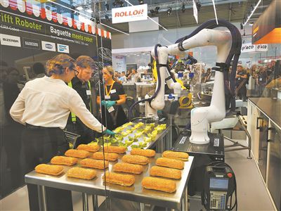 机器人制造商发那科（FANUC）在展会上展示机器人做汉堡包。