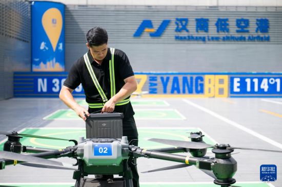 6月16日，在汉商低空港停机坪，一名工作人员给无人机更换电池。新华社记者 伍志尊 摄