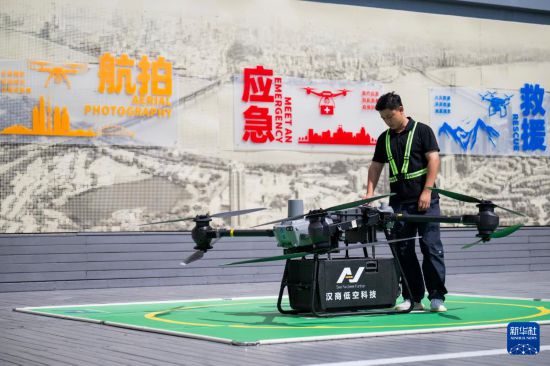 6月16日，在汉商低空港停机坪，一名工作人员在起飞前检查无人机工作状态。新华社记者 伍志尊 摄
