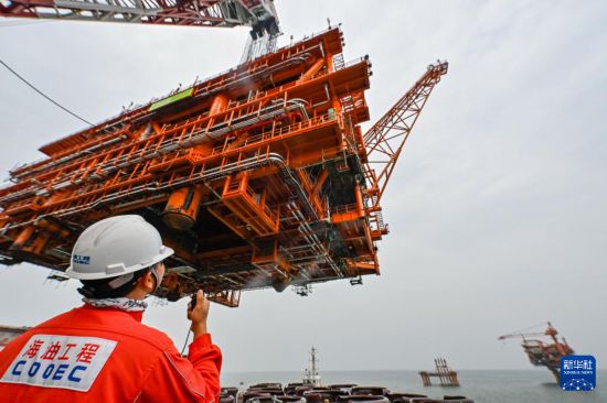 9月8日，工人在垦利6-1油田10-1北区块Ⅱ期开发项目油气平台安装作业现场指挥吊装。  新华社发（杜鹏辉摄）