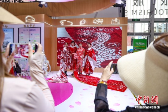 身着剪纸图案服饰的演员吸引观众拍照。