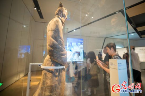觀眾近距離參觀兵馬俑展櫃,屏幕展示兵馬俑出土位置實時情況