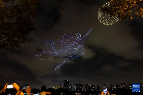 9月27日，市民游客在上海世纪公园观看无人机灯光秀。     新华社记者 王翔 摄