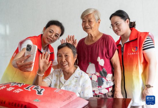 10月5日，江蘇省南通市通州區金新街道界北村志願者幫助老人與遠在海外的子女進行視頻通話，“雲端”相聚，共迎中秋。     新華社發（翟慧勇攝）