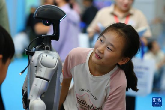 10月2日，在山東省第九屆滕州書展現場，小朋友與機器人互動。     新華社發（李志軍攝）