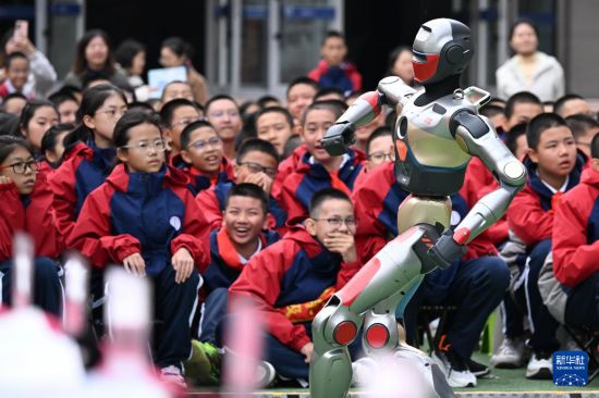 10月13日，新疆生產建設兵團第一中學學生在科技節開幕式上觀看智能機器人跳舞。     新華社記者 王菲 攝