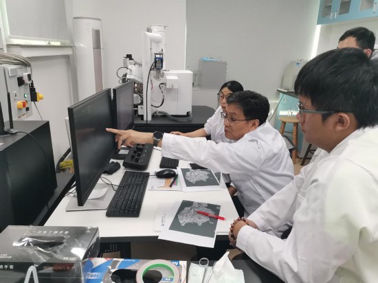 2024年8月26日，徐义刚院士与团队成员通过扫描电镜观察嫦娥六号样品特征。（中国科学院广州地球化学研究所供图）