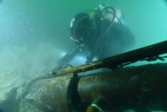 水下考古队员在山东威海湾来远舰遗址进行抽沙作业（资料照片）。新华社发