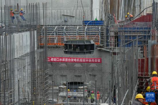 12月20日，在青峪口水库施工现场，工程机械在进行发电机组部件吊装作业。     新华社记者 王曦 摄