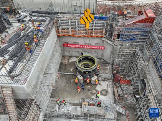 12月20日，在青峪口水库施工现场，工程机械在进行发电机组部件吊装作业（无人机照片）。     新华社记者 王曦 摄