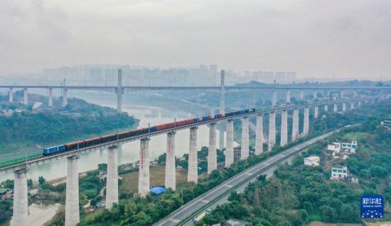  12月25日，隆瀘敘鐵路首發貨運列車駛過瀘州金山沱江鐵路大橋（無人機照片）。       新華社發（牟科 攝）