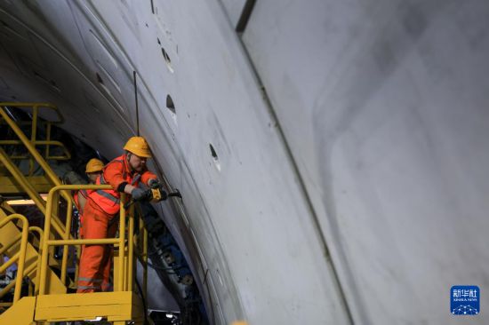 1月6日，中铁十四局施工人员在“深江1号”盾构机上进行管片螺栓紧固工作。新华社记者 毛思倩 摄