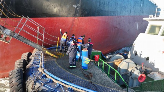 图为救援人员乘坐破冰船转接生病船员。新华社发