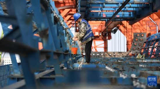 1月28日，在東莞市濱海灣新區的深江鐵路跨沿江高速特大橋施工現場，中鐵十一局工人在進行鋼筋綁扎工作。新華社記者 鄧華 攝