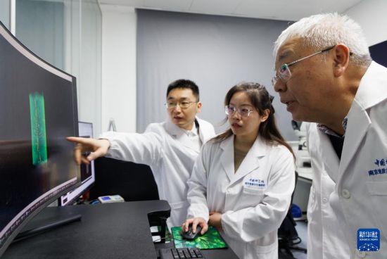 1月22日，在中國科學院南京地質古生物研究所顯微CT實驗室，中國科學院院士、研究員朱茂炎（右一），副研究員曾晗（左一）和同事觀察掃描出來的化石圖。新華社記者 金立旺 攝