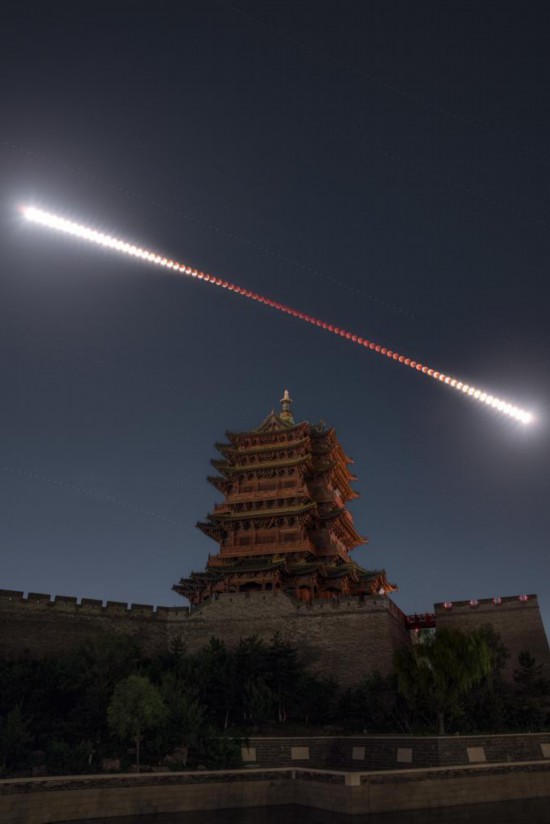 2025年9月7日夜晚至8日凌晨,在山西大同古城牆乾樓拍攝的月全食軌跡(多張堆棧),形似“金箍棒”。新華社發(韓享 攝)
