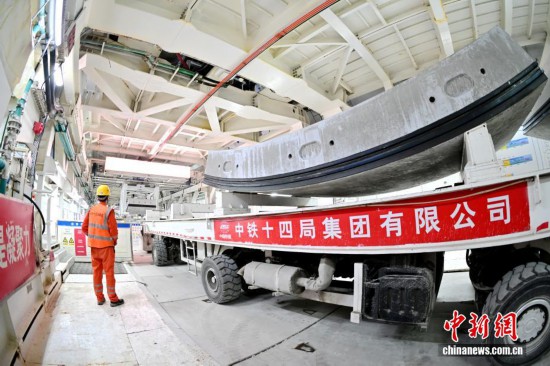 图为工人正进行隧道管片的吊运作业。丁翔 摄