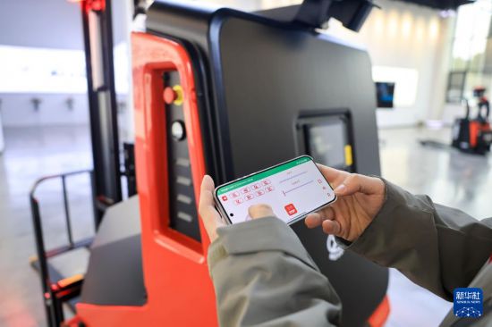 3月16日,在江苏江阴—靖江工业园区江苏中力叉车有限公司展厅内,技术人员在演示掏箱机器人。新华社发(顾继红 摄)