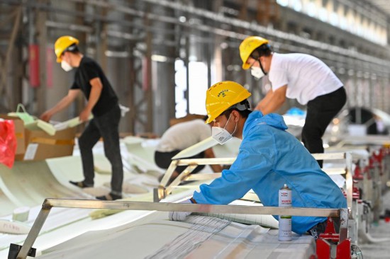 这是2023年7月22日拍摄的在新疆塔城重点开发开放试验区先行发展区三一（塔城）风电设备有限公司，工人在叶片成型车间忙碌。新华社记者丁磊 摄